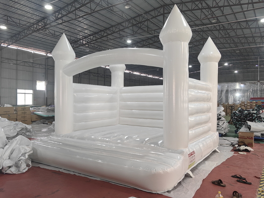 Une maison de saut pour les tout-petits, une décoration de mariage, un videur, un château gonflable blanc.